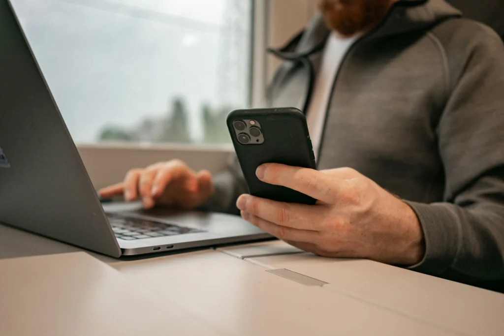Un propriétaire de salon gère ses réservations en ligne sur son téléphone et son ordinateur portable