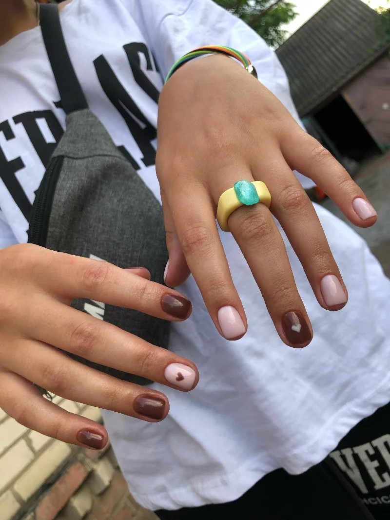 Femme en t-shirt blanc montrant sa manucure BIAB à lappareil photo en extérieur