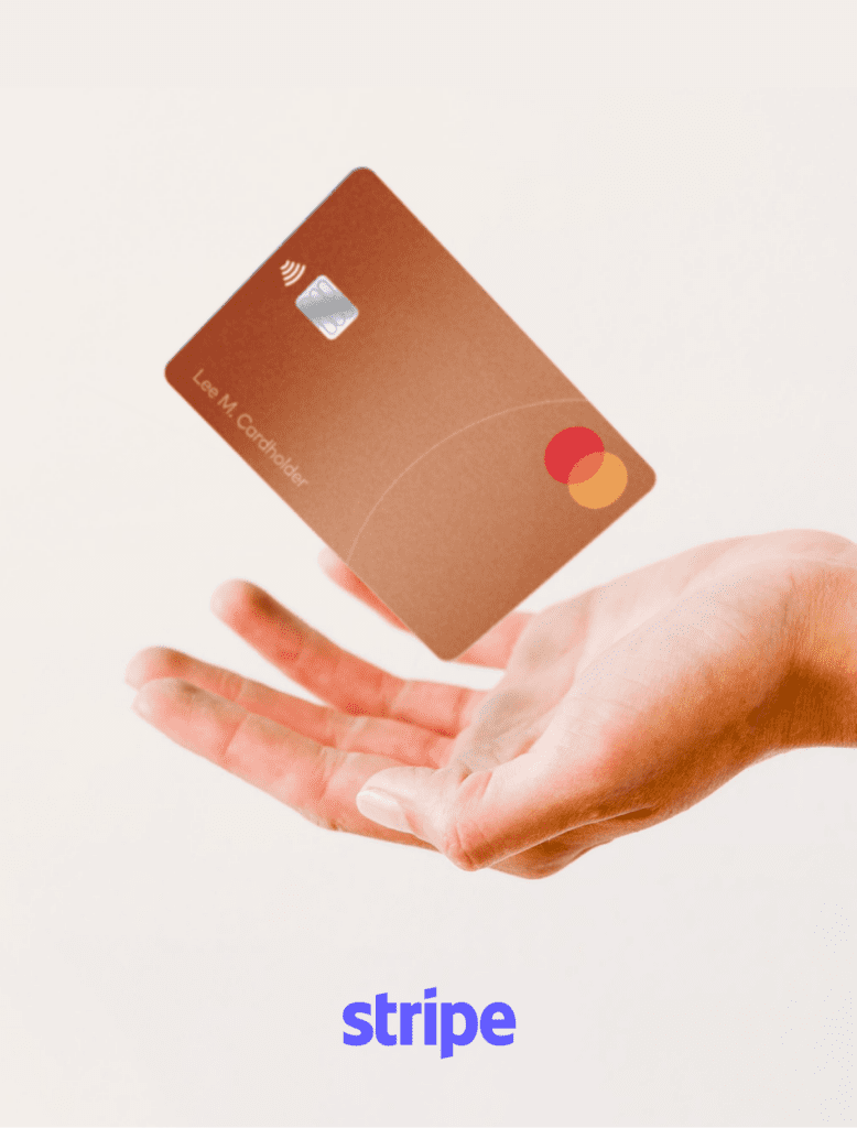 Primo piano di una mano aperta con una carta di credito Mastercard color bronzo che vola appena sopra il palmo, su uno sfondo bianco neutro. In basso compare la scritta "stripe" in carattere blu.