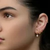 Foto in studio di una donna con un curated ear, con svariati piercing al lobo e un cerchietto all’helix
