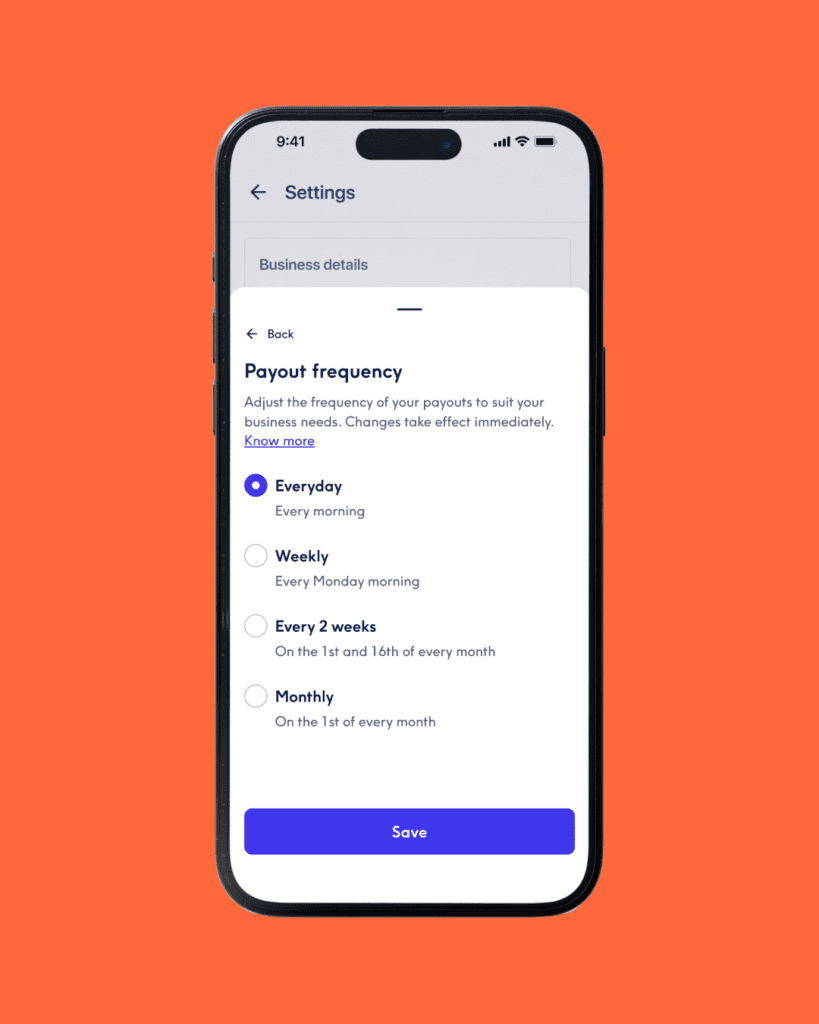 Nahaufnahme eines Smartphone-Bildschirms vor einem leuchtend orangefarbenen Hintergrund, der das Einstellungsmenü „Payout frequency“ (Auszahlungshäufigkeit) anzeigt. Die ausgewählte Option ist „Everyday“ (Täglich), mit weiteren nicht ausgewählten Optionen für „Weekly“, „Every 2 weeks“ und „Monthly“. Unten befindet sich eine blaue Schaltfläche „Save“.