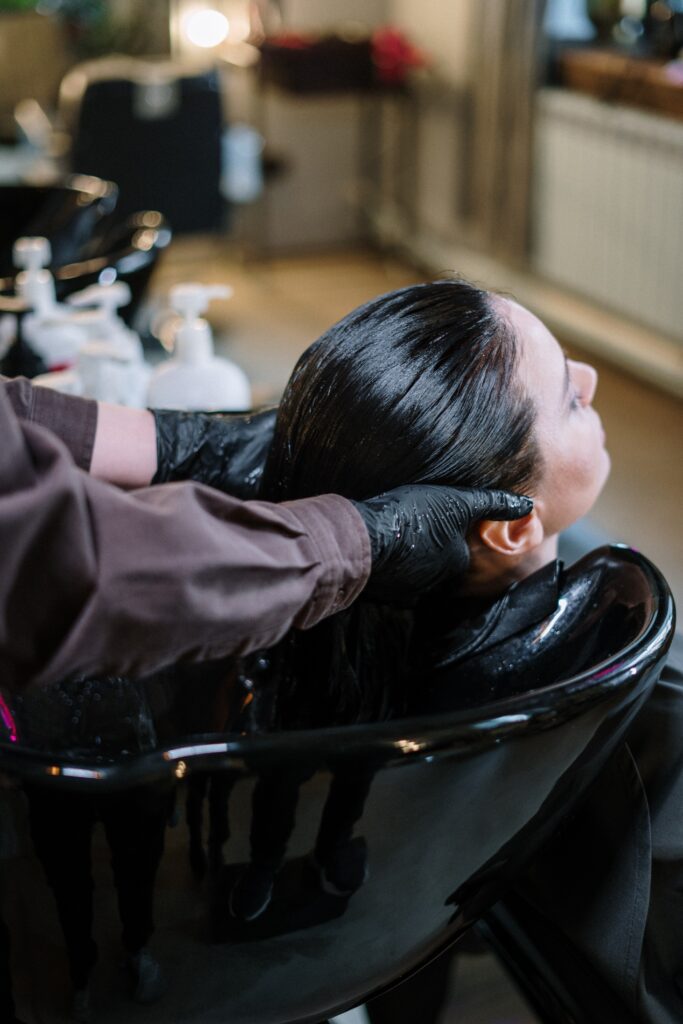 Einer Frau werden die Haare in einem Coiffeursalon gewaschen.