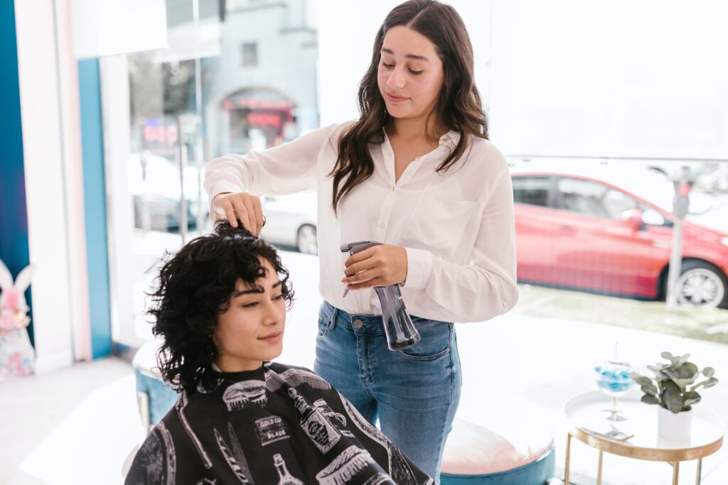 Coiffeurin frisiert Kundin die Haare