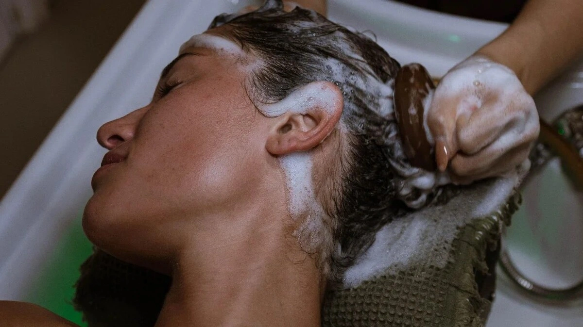 Nahaufnahme einer Fachkraft, die einen Japanese Head Spa mit einer Kopfhautbürste an einer Kundin durchführt