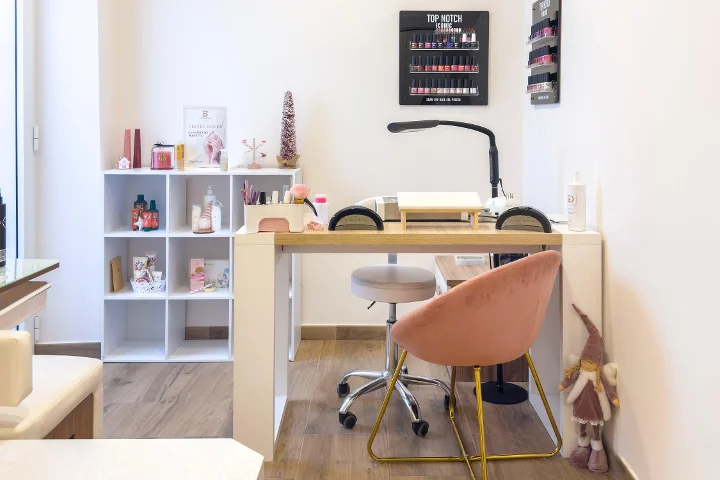 Nagelstation bei Gd Beauty Clinc di Giulia Delogu in Alghero mit rosa Samtstuhl und Top-Notch-Nagellack-Display.