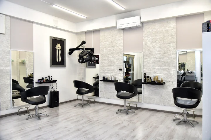 Moderne Styling-Plätze bei Sp Beauty di Serena Pinna nahe der Pittulongu-Strände in Olbia, mit schwarzen Stühlen und grossen Spiegeln.