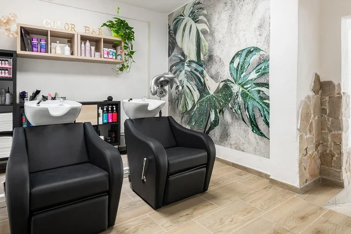 Waschplätze und Color Bar im Yourself in Tortolì mit einem tropischen Monstera-Wandbild.